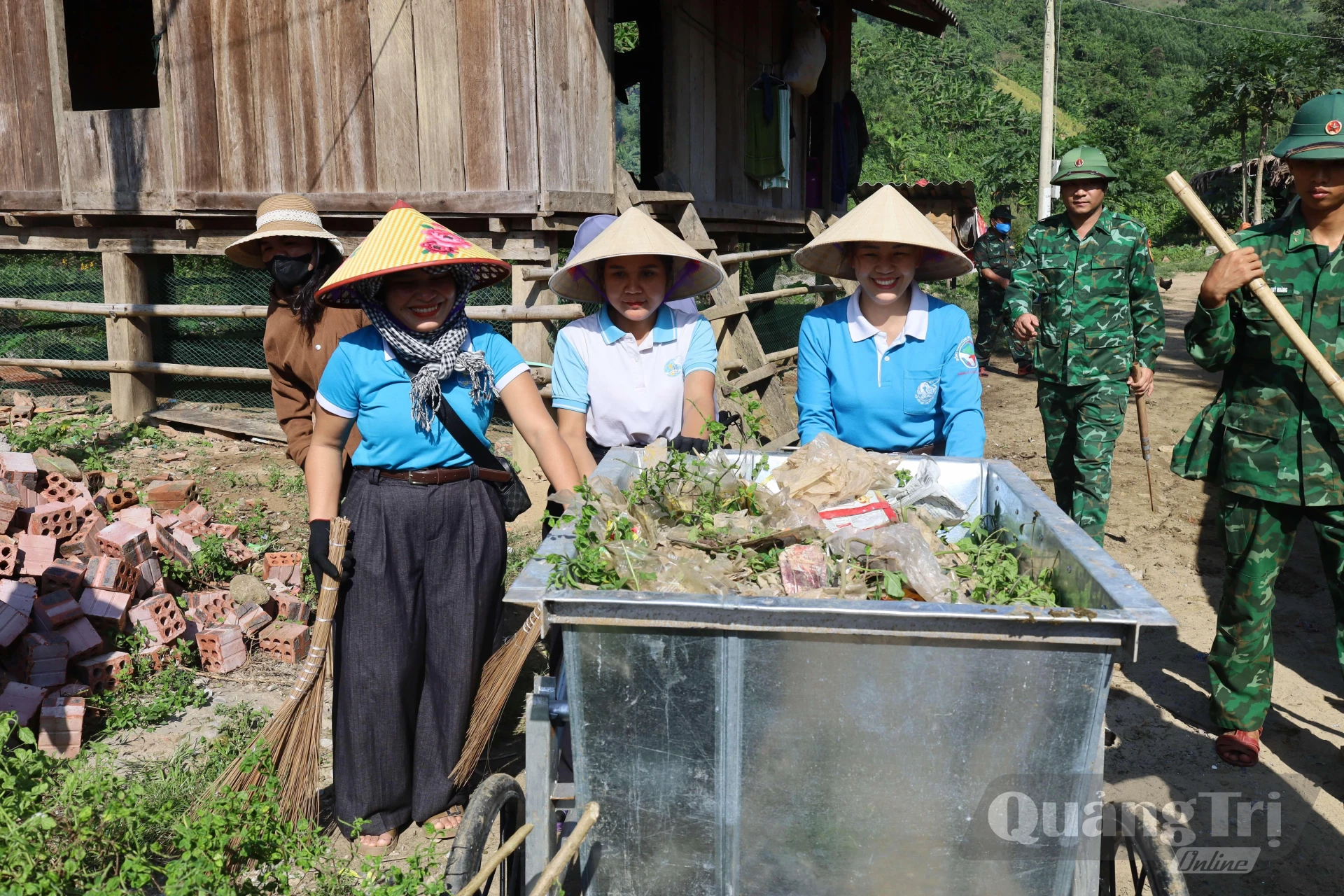 Hội LHPN xã Dân Hóa cùng cán bộ, chiến sĩ Bộ đội Biên phòng thu gom rác thải, vệ sinh khuôn viên nhà ở tại bản Lòm- K. Chăm, xã Dân Hóa, góp phần giữ gìn môi trường bản làng sạch đẹp - Ảnh: Q.N.