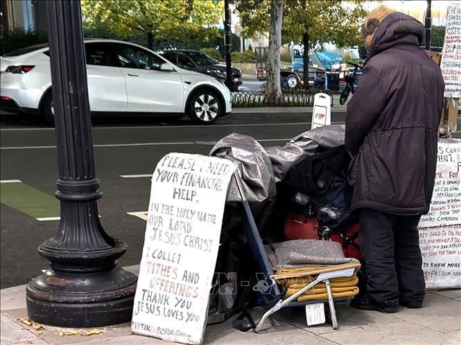 Một người vô gia cư với tấm biển cần giúp đỡ về tài chính trên một tuyến phố ở trung tâm thủ đô Washington D.C. Ảnh: Ngọc Quang - PV TTXVN tại Mỹ