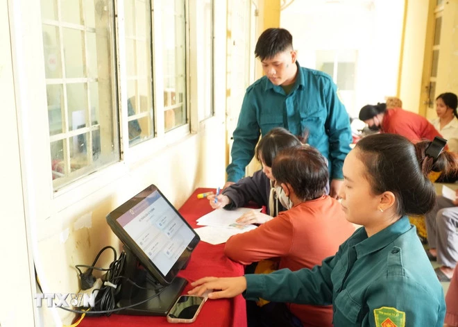 Lực lượng dân phòng ở xã Thái Mỹ (Thành phố Hồ Chí Minh) tham gia hướng dẫn người dân làm thủ tục dịch vụ công trực tuyến. (Ảnh: Hữu Duyên/TTXVN)