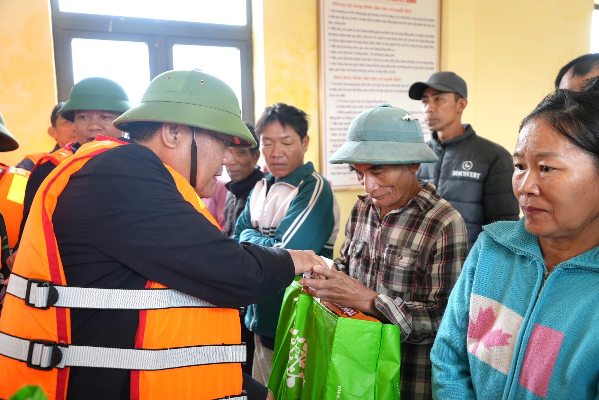 Đồng chí Chủ tịch UBND tỉnh Trần Phong tặng quà cho người dân tại nhà chống bão lũ cộng đồng thôn Hữu Tân, xã Ninh Châu - Ảnh: Trung Đức