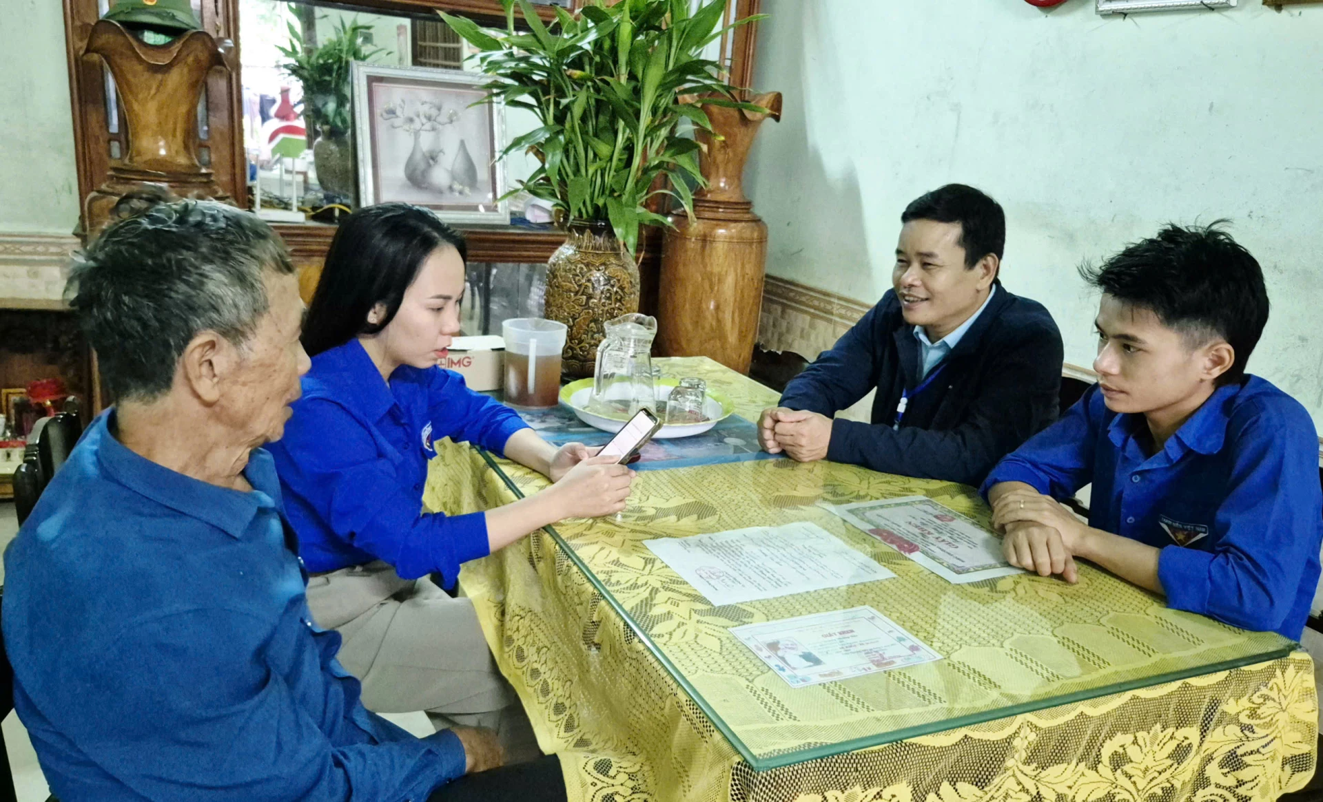 Đoàn viên, thanh niên hướng dẫn người dân đăng ký thủ tục hành chính qua thiết bị điện thoại thông minh tại nhà - Ảnh: K.S