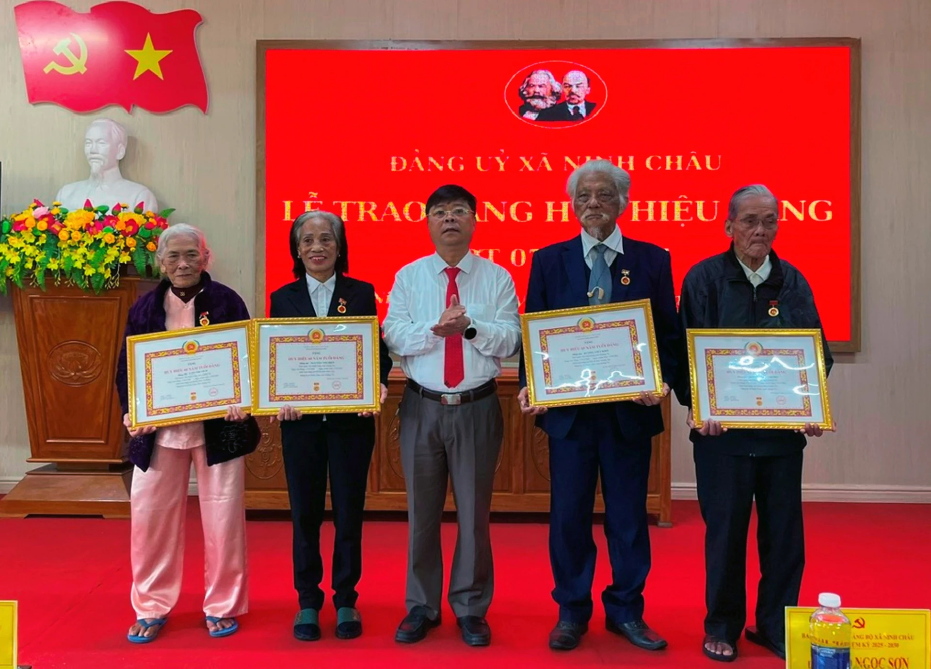 Lãnh đạo xã Ninh Châu trao Huy hiệu Đảng cho các đảng viên - Ảnh: L.C