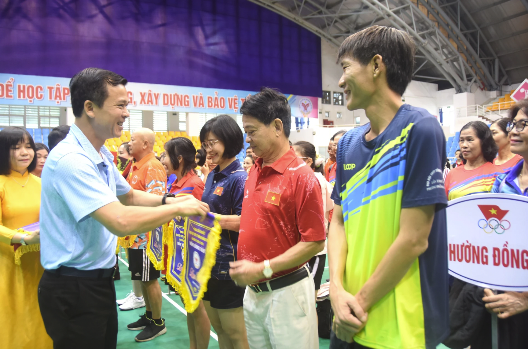 Ban tổ chức trao tặng hoa, cờ lưu niệm cho các đoàn VĐV - Ảnh: ĐV