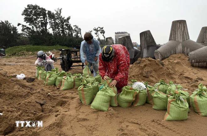 Người dân phường Tuy Hòa khẩn trương làm bao cát chèn chống nhà cửa. (Ảnh: Tường Quân/TTXVN)