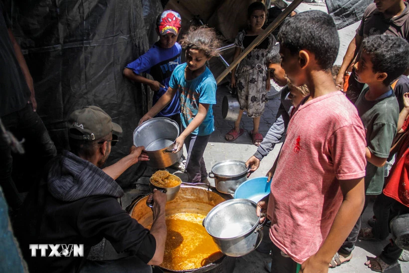 Các em nhỏ nhận thực phẩm cứu trợ tại Jabalia, Dải Gaza. (Ảnh: THX/TTXVN)