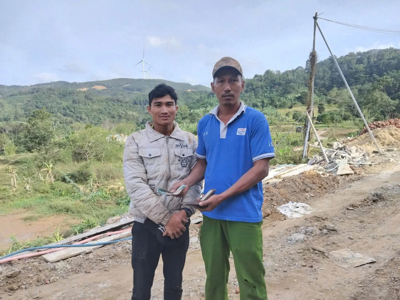 Anh Nguyễn Ngọc Vũ trao trả ví, giấy tờ và số tiền nhặt được cho anh Hồ Da Cốp - Ảnh: NĐ