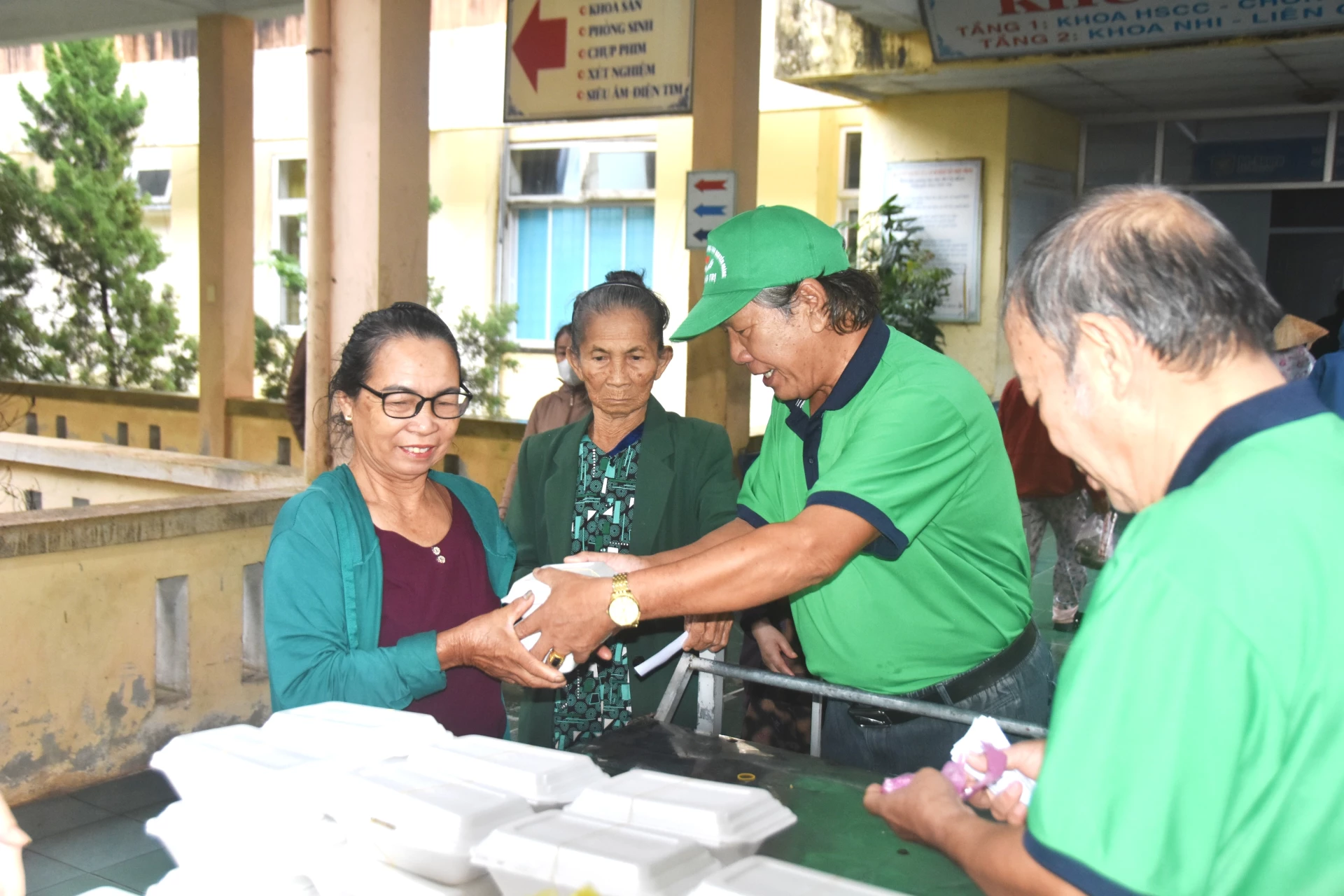 Các thành viên nhóm thiện nguyện cựu học sinh Nguyễn Hoàng – Quảng Trị phát cơm cho bệnh nhân - Ảnh: Đ.V