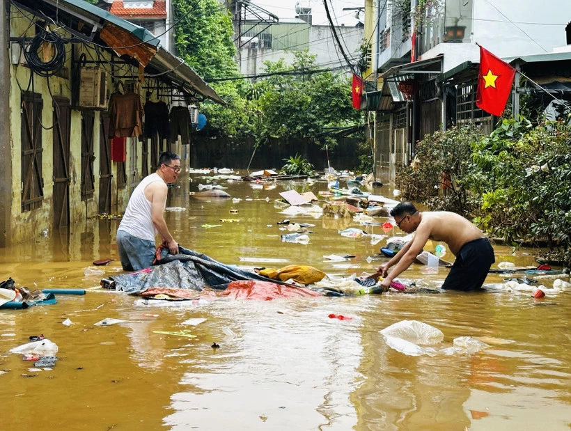 Người dân dọn dẹp nhà cửa sau trận lụt. (Ảnh: Đức Thọ/TTXVN)