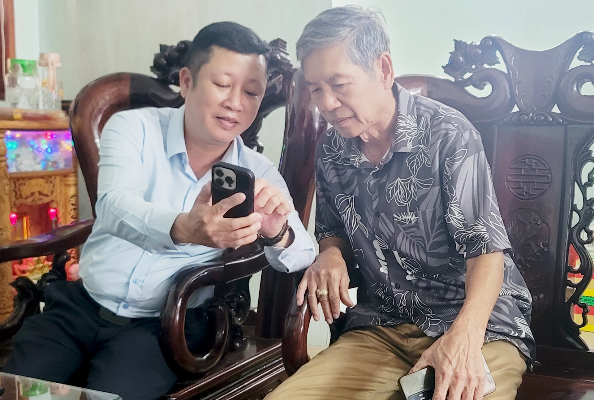 Cán bộ Ủy ban MTTQVN phường Quảng Trị hướng dẫn cho người dân tham gia góp ý vào các dự thảo Văn kiện đại hội Đảng thông qua ứng dụng VNeID - Ảnh: T.L