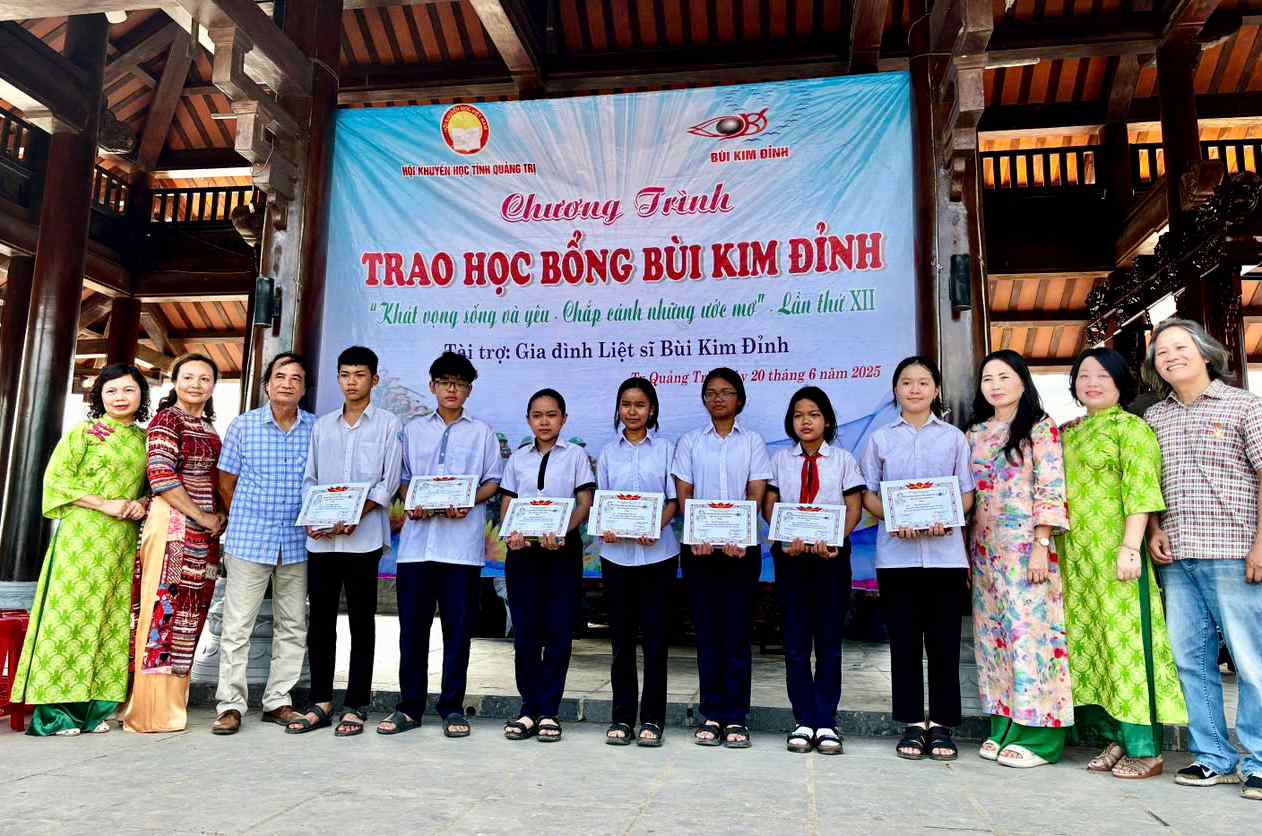 Lãnh đạo Hội Khuyến học tỉnh và thân nhân liệt sĩ Bùi Kim Đỉnh trao học bổng cho học sinh có hoàn cảnh khó khăn- Ảnh: Q.H