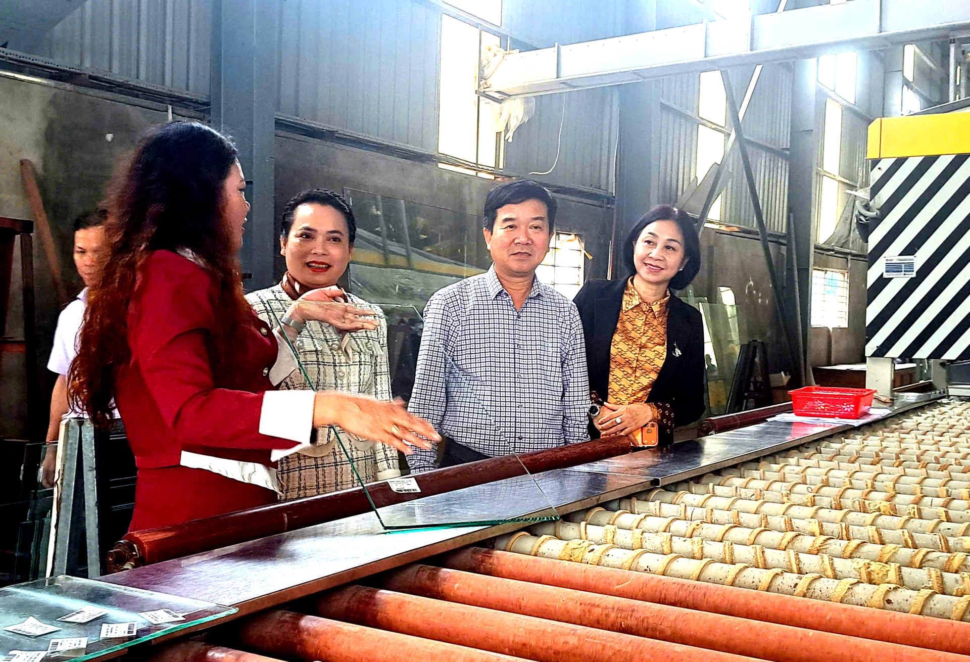 Đoàn công tác thăm nhà máy sản xuất kính cường lực tại Cụm công nghiệp Nghĩa Ninh. Ảnh: H.Tr