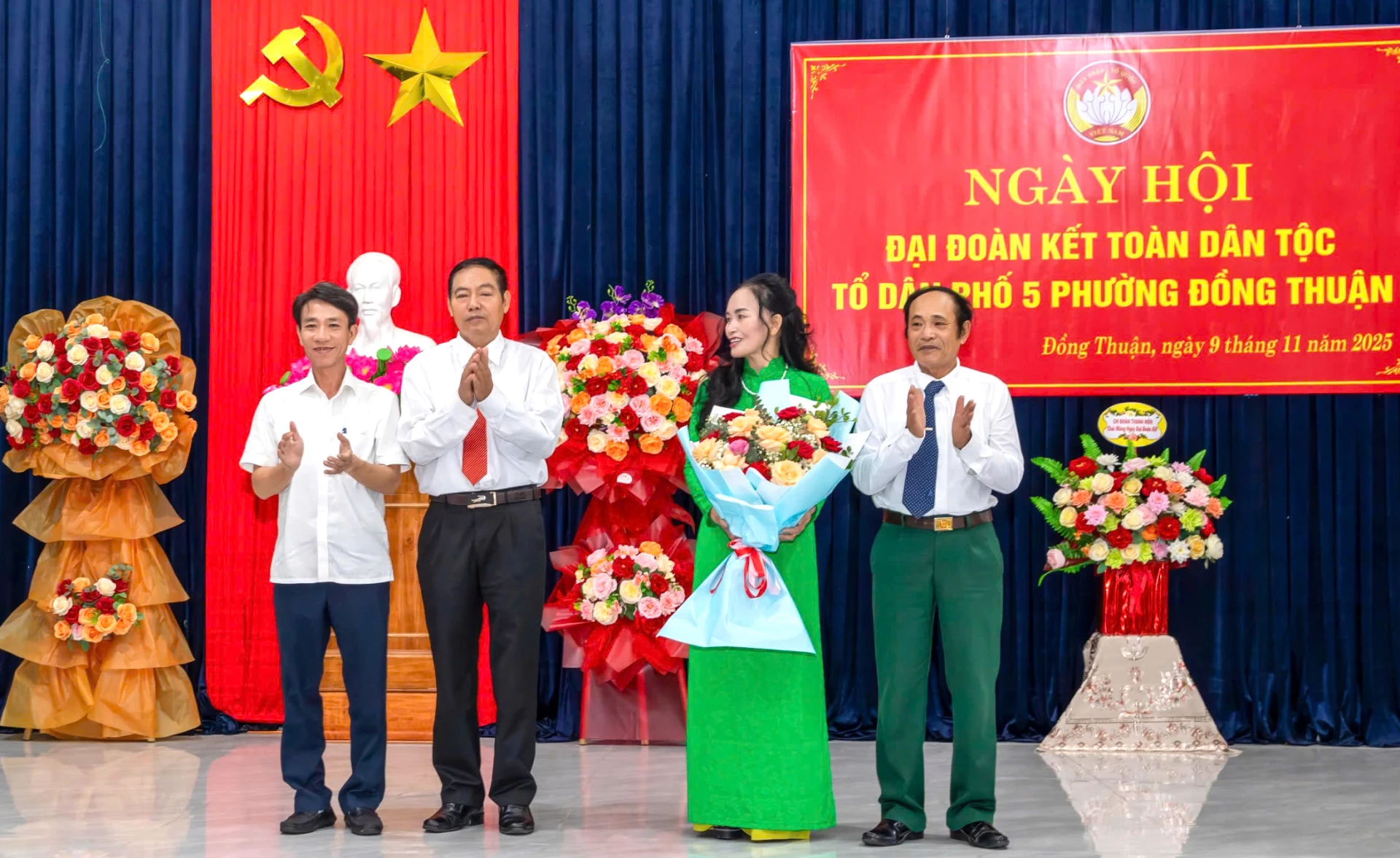 Bí thư Đảng ủy phường Đồng Thuận Nguyễn Nguyên Lực tặng hoa chúc mừng bà con tổ dân phố 5. Ảnh: H.Tr.