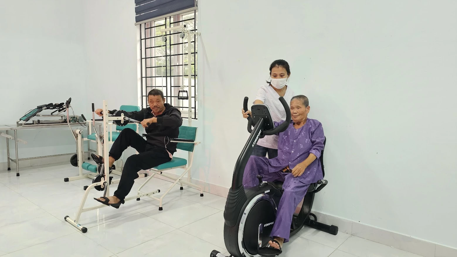 Kỹ thuật viên Trung tâm Công tác xã hội Nam Quảng Trị tận tình hỗ trợ, giúp đỡ các đối tượng khó khăn từng bước tìm lại chức năng vận động - Ảnh: T.T