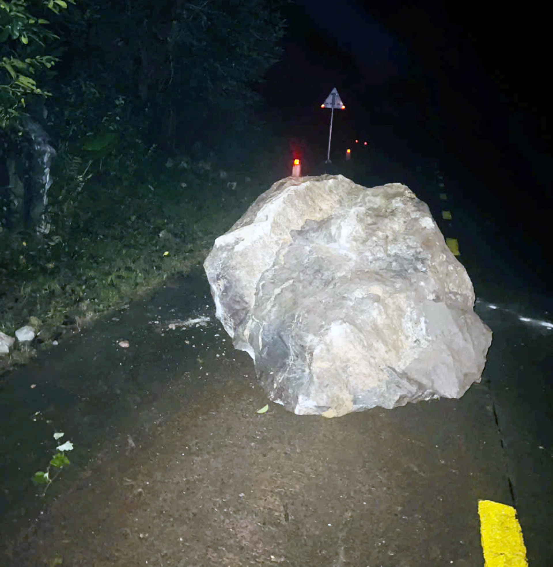 Tảng đá lớn từ trên núi lăn xuống đường Hồ Chí Minh nhánh Tây, đoạn qua thôn Hồng Sơn, xã Trường Sơn - Ảnh: CTV