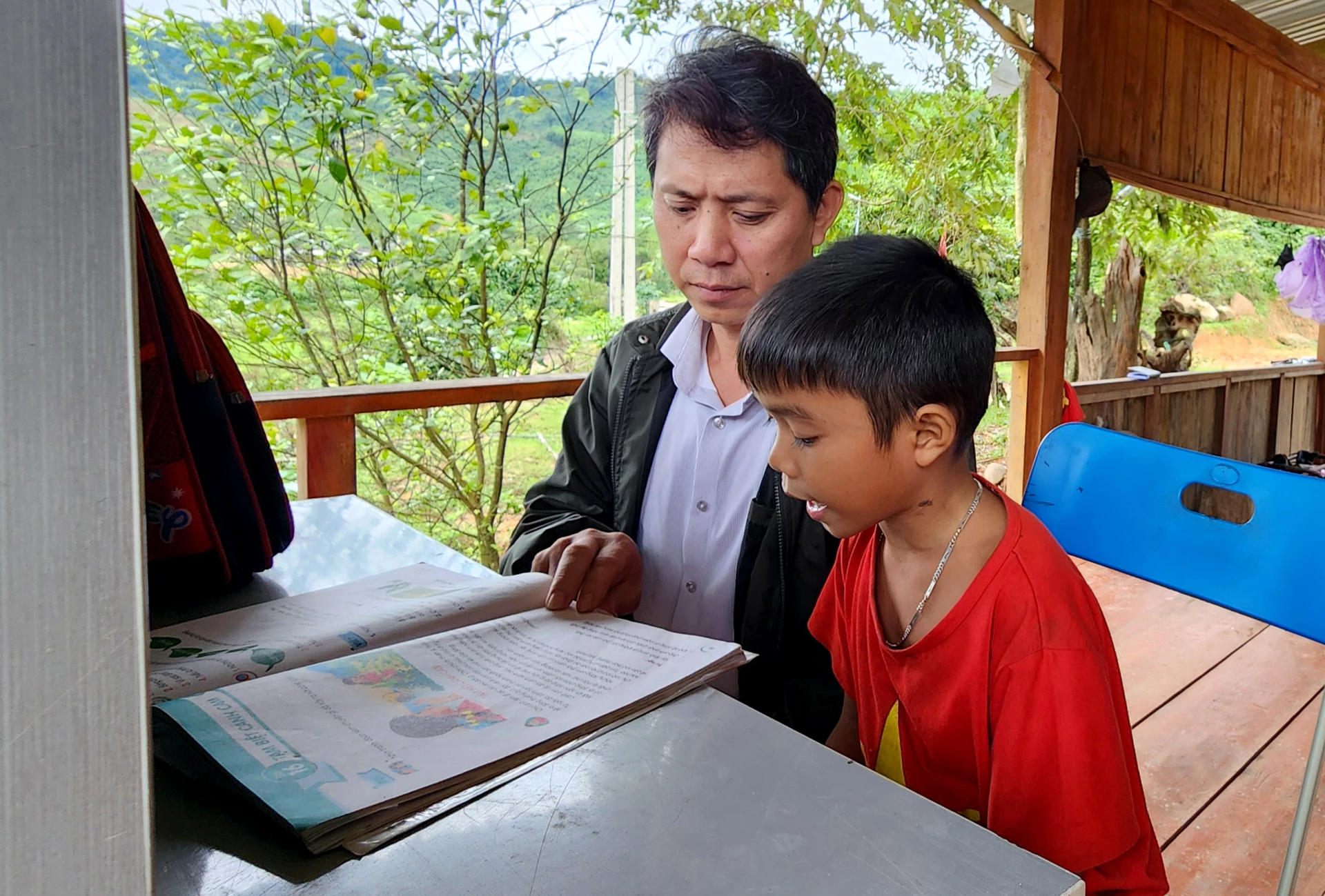 Anh Phan Văn Tý luôn theo sát việc học tập của con trai Trần Văn Hoàng   - Ảnh: T.L