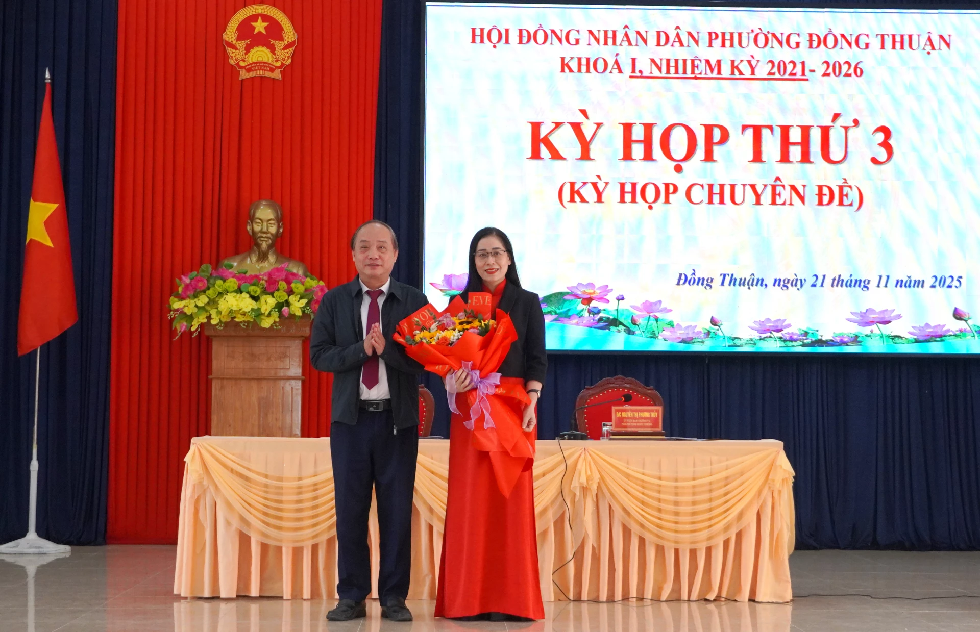 Chủ tịch HĐND phường Đồng Thuận tặng hoa bà Nguyễn Thị Việt Hà, Trưởng phòng Văn hóa-xã hội phường Đồng Thuận, nhiệm kỳ 2021-2026. Ảnh: H.Tr.