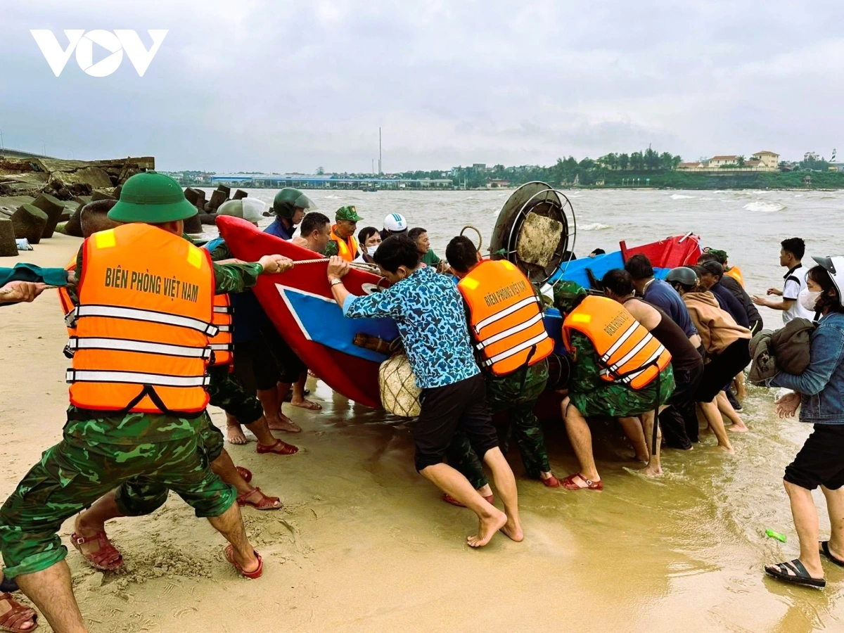 Cán bộ, chiến sĩ Đồn Biên phòng Cửa Tùng cùng các lực lượng và người dân cứu hộ tàu lên bờ