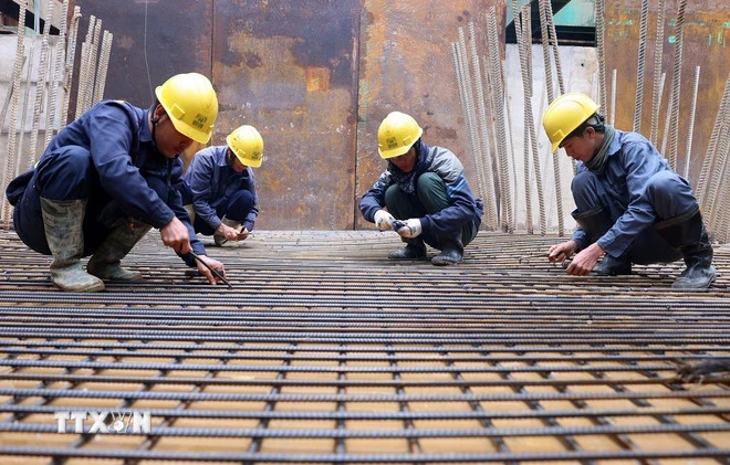 Các kỹ sư, công nhân đang ngày đêm vượt nắng, thắng mưa để đảm bảo tiến độ thi công Dự án. (Ảnh: Quốc Khánh/TTXVN)