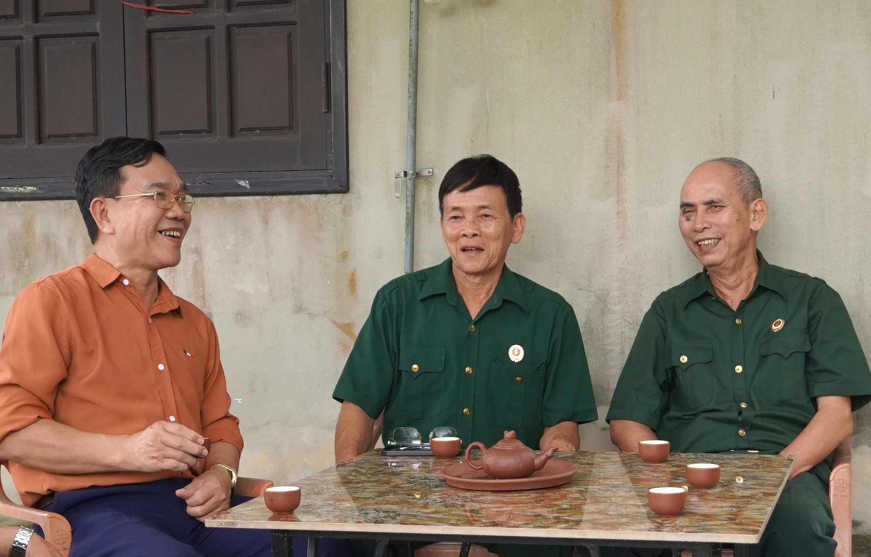 Cựu chiến binh Hoàng Thanh Long (ở giữa) trao đổi, chuyện trò cùng đồng đội - Ảnh: H.TR