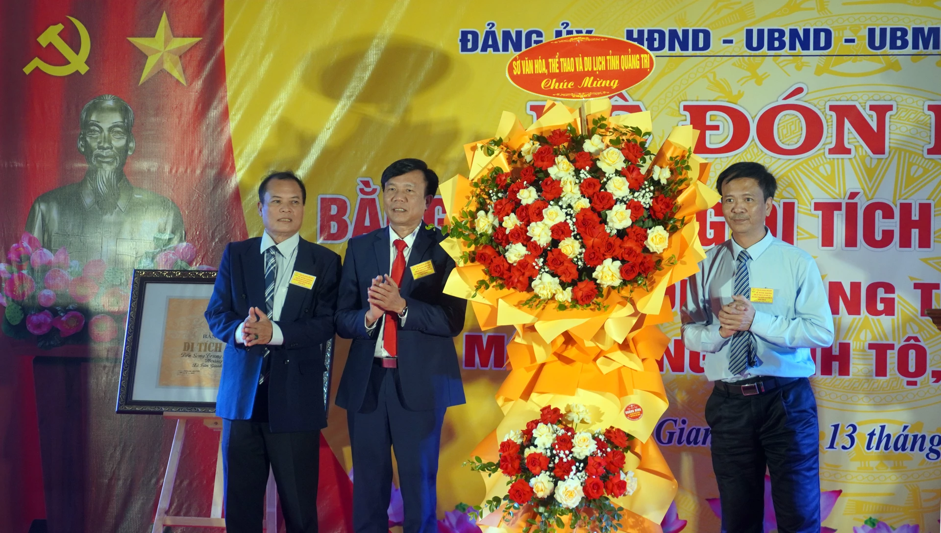 Đại diện lãnh đạo Sở VH-TT và DL trao lẵng hoa chúc mừng của đồng chí Hồ An Phong, Thứ trưởng Bộ VH-TT và DL - Ảnh: N.M