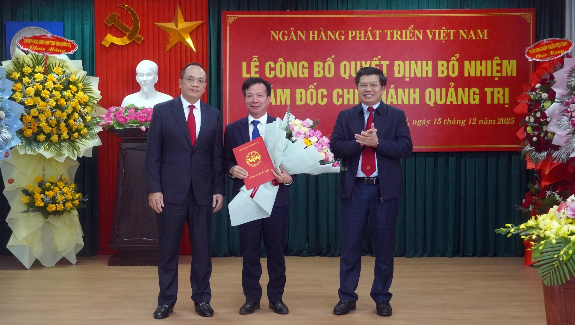 Đồng chí Trần Vũ Khiêm, Phó Bí thư Thường trực Tỉnh ủy và đồng chí Lê Văn Hoan, Bí thư Đảng ủy, Chủ tịch Hội đồng quản trị NHPT Việt Nam chúc mừng đồng chí Lê Quang - Ảnh: N.M