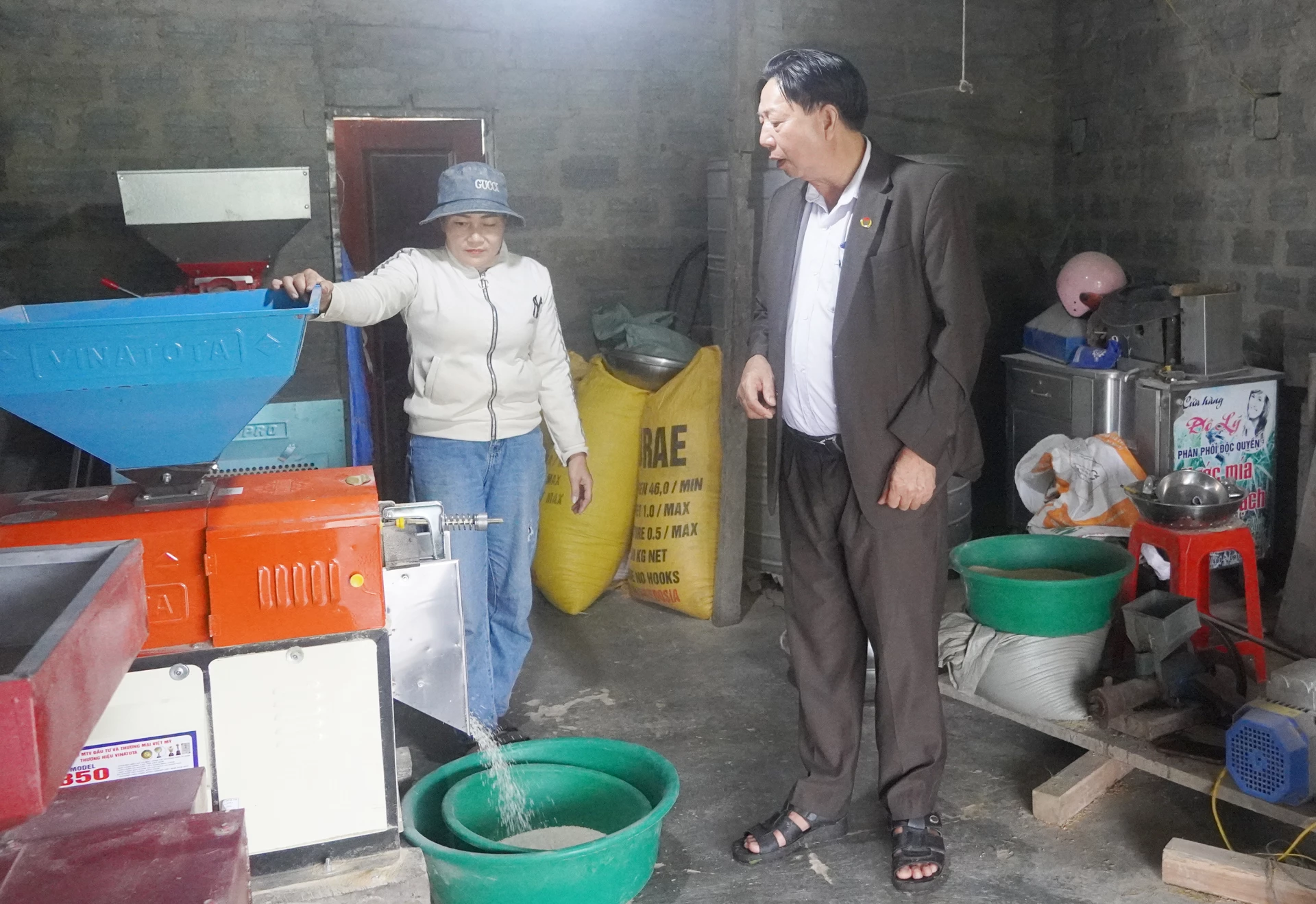 Ông Nguyễn Văn Lợi kiểm tra sản xuất cốm gạo của người dân trong thôn - Ảnh: X.V