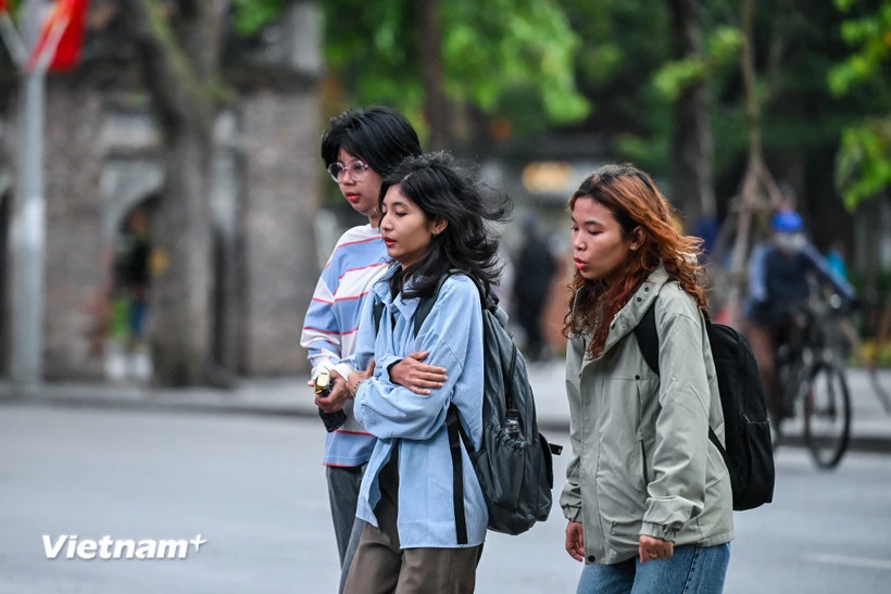 Những vị khách du lịch co ro trong trời lạnh vào sáng sớm ở Thủ đô. (Ảnh: Minh Sơn/Vietnam+)