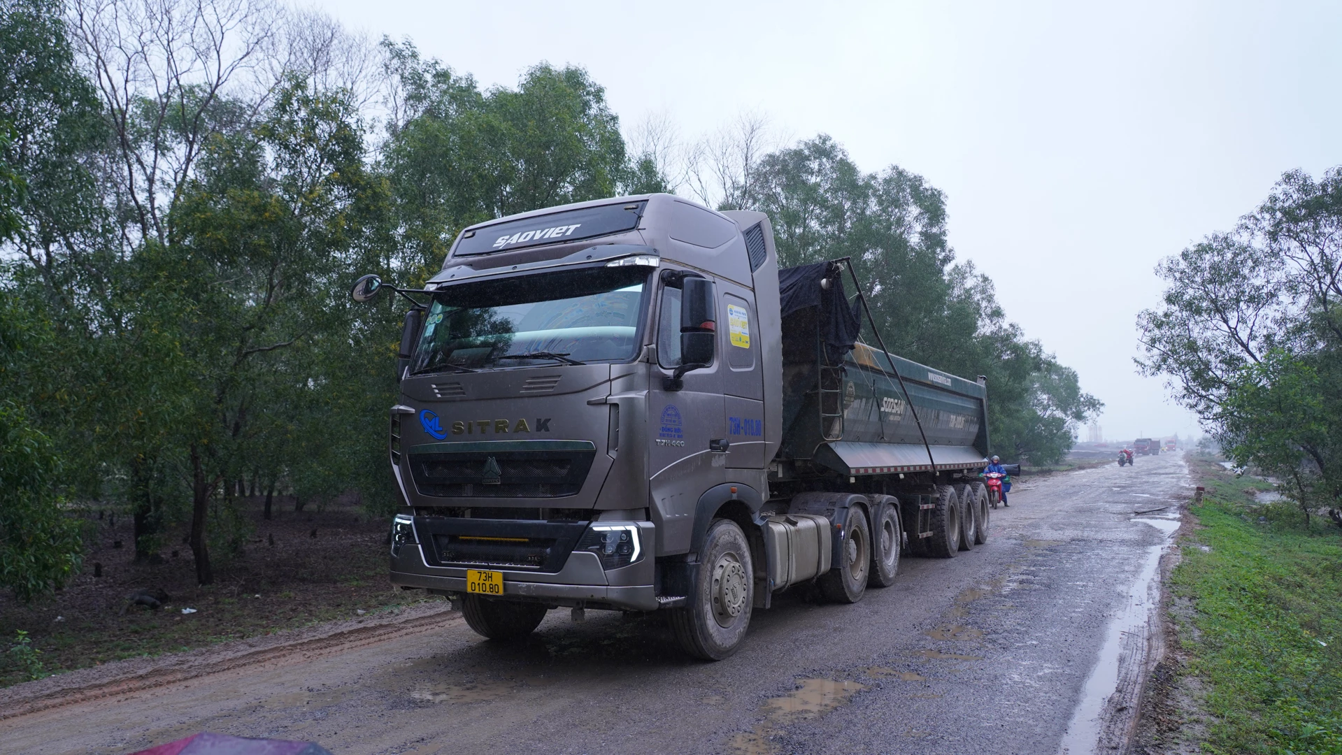 Nhiều xe tải nặng chạy chiếm hết phần đường dành cho người đi xe máy - Ảnh: Lê Trường