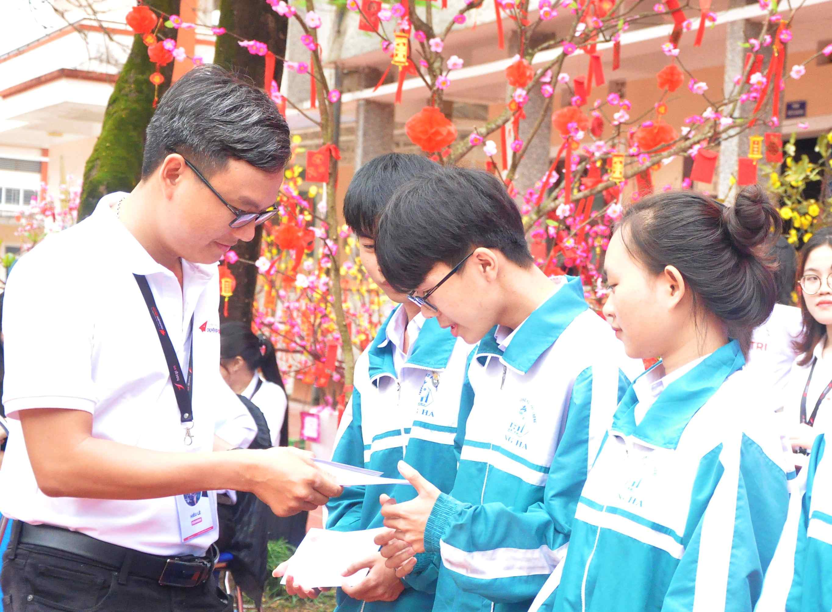 Đại diện nhóm Tư vấn tuyển sinh Quảng Trị trao học bổng cho học sinh khó khăn - Ảnh: Q.H