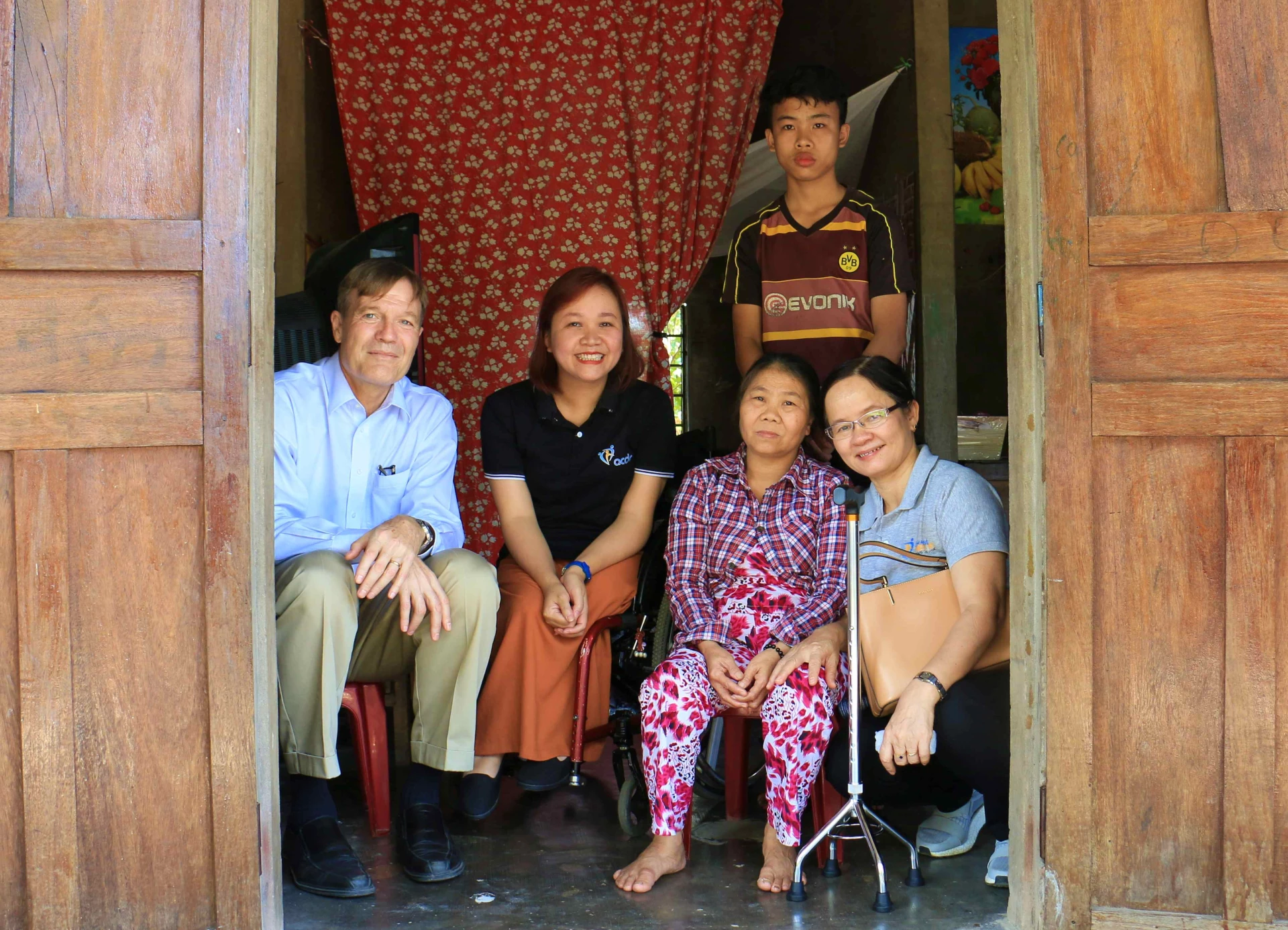 Bà Nguyễn Thị Lan Anh và những người cùng chí hướng đến thăm hỏi, động viên và chụp ảnh lưu niệm với một gia đình người khuyết tật. Ảnh: Q.H