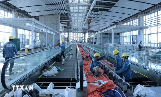 Nhân viên kỹ thuật hoàn thiện cầu thang bộ hành nhà ga hành khách sân bay Long Thành. (Ảnh: Công Phong/TTXVN)