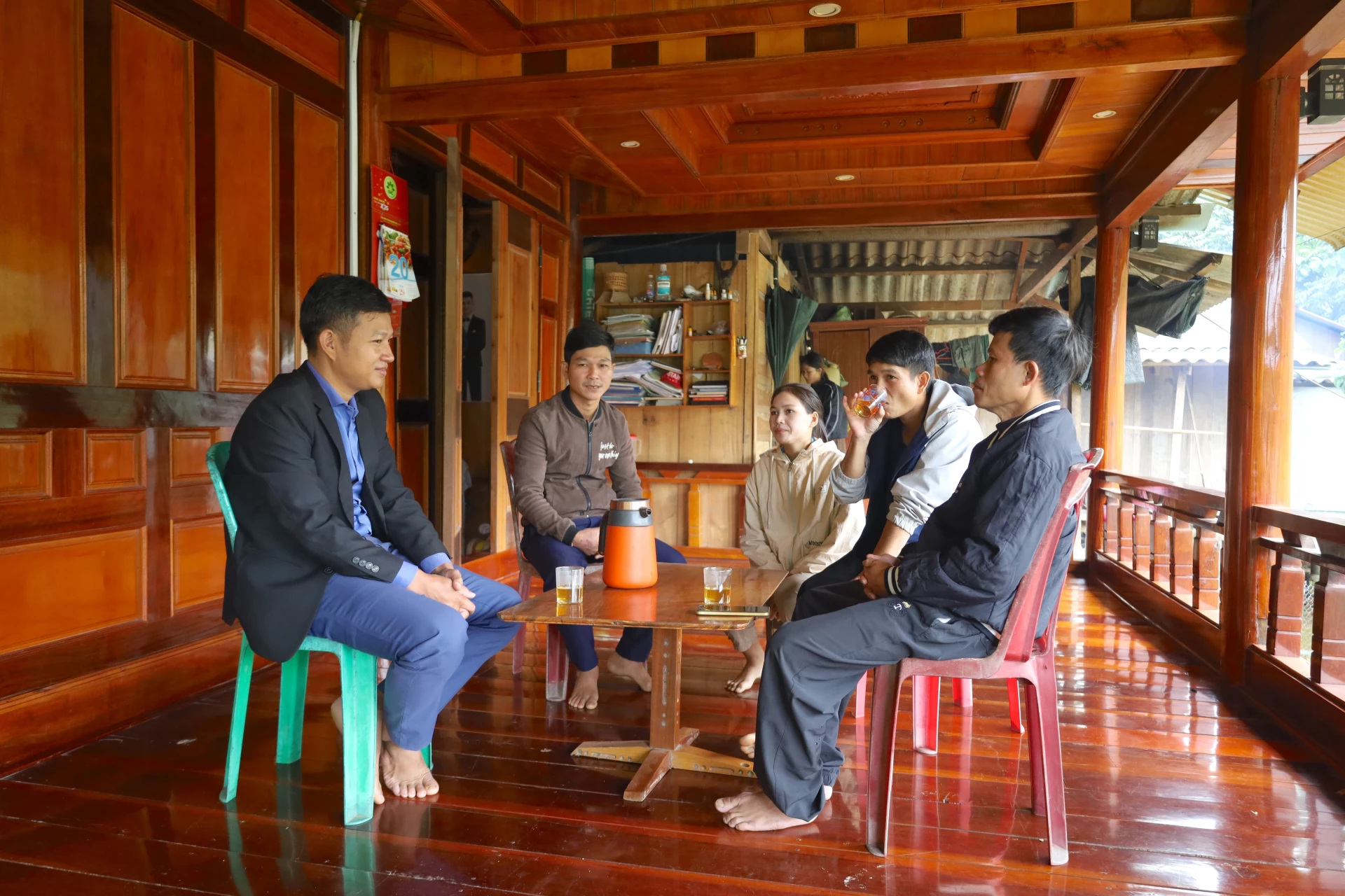 Buổi sinh hoạt chi bộ trong căn nhà gỗ của Bí thư Chi bộ bản K Định Hồ Bông (thứ 2 từ bên trái qua) - Ảnh: Q.N