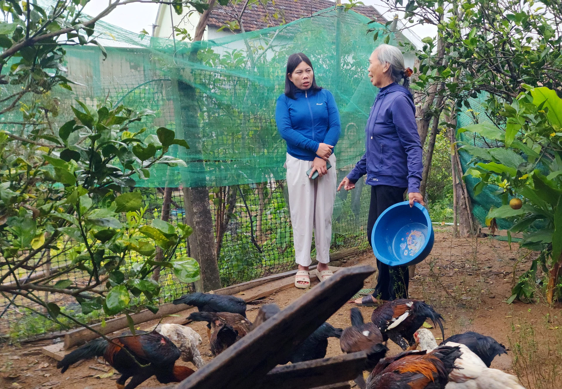 Nữ trưởng thôn ba cùng với dân Lê Thị Sinh Thương (bìa trái) - Ảnh: T.L