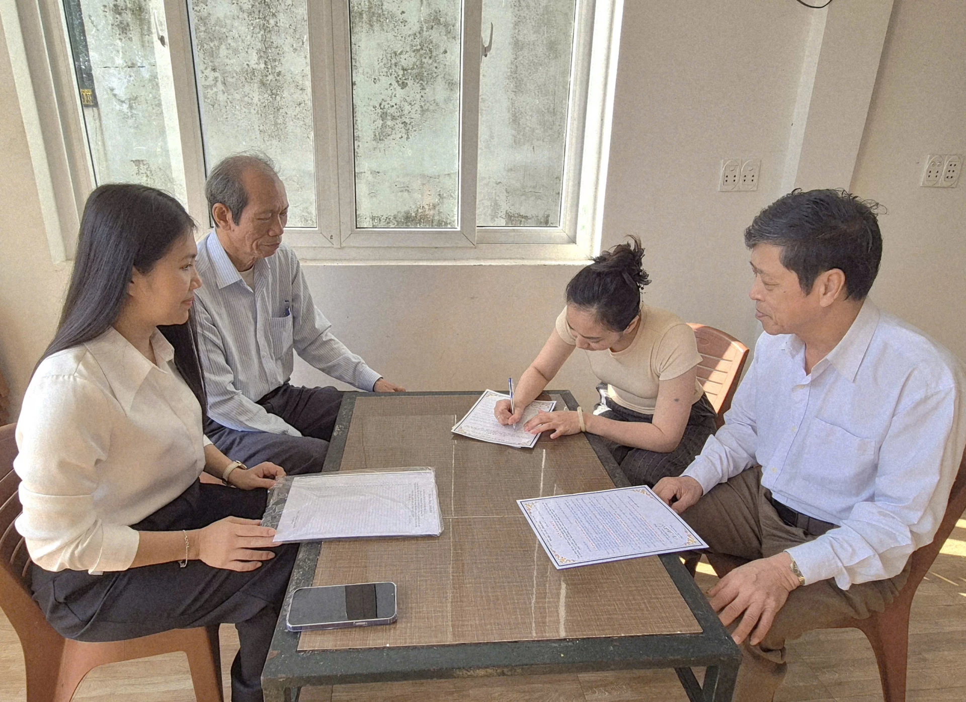 Cán bộ Mặt trận phường Quảng Trị tuyên truyền, vận động người dân ký cam kết thực hiện Đề án 359 - Ảnh: K.S