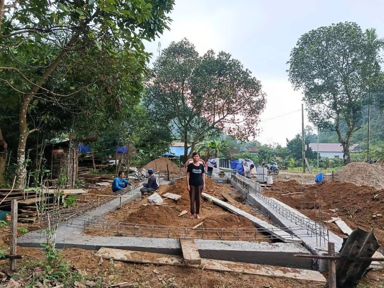 Bà Hồ Thị Hồng, ở bản Cà Xen, xã Tuyên Lâm bên công trình nhà ở đang được khẩn trương xây dựng - Ảnh: T.H