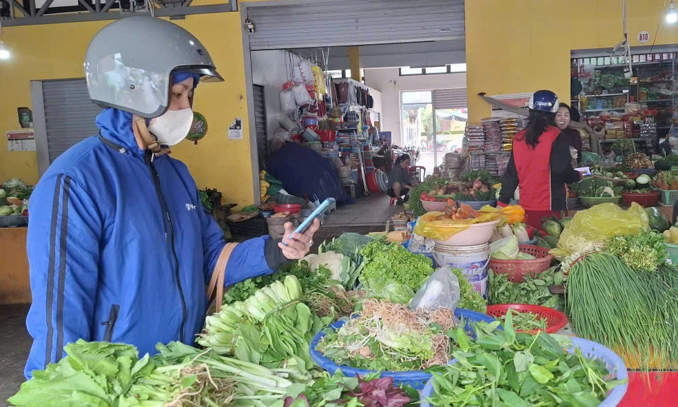 Giao dịch không dùng tiền mặt trở nên phổ biến tại các chợ truyền thống - Ảnh: M.N