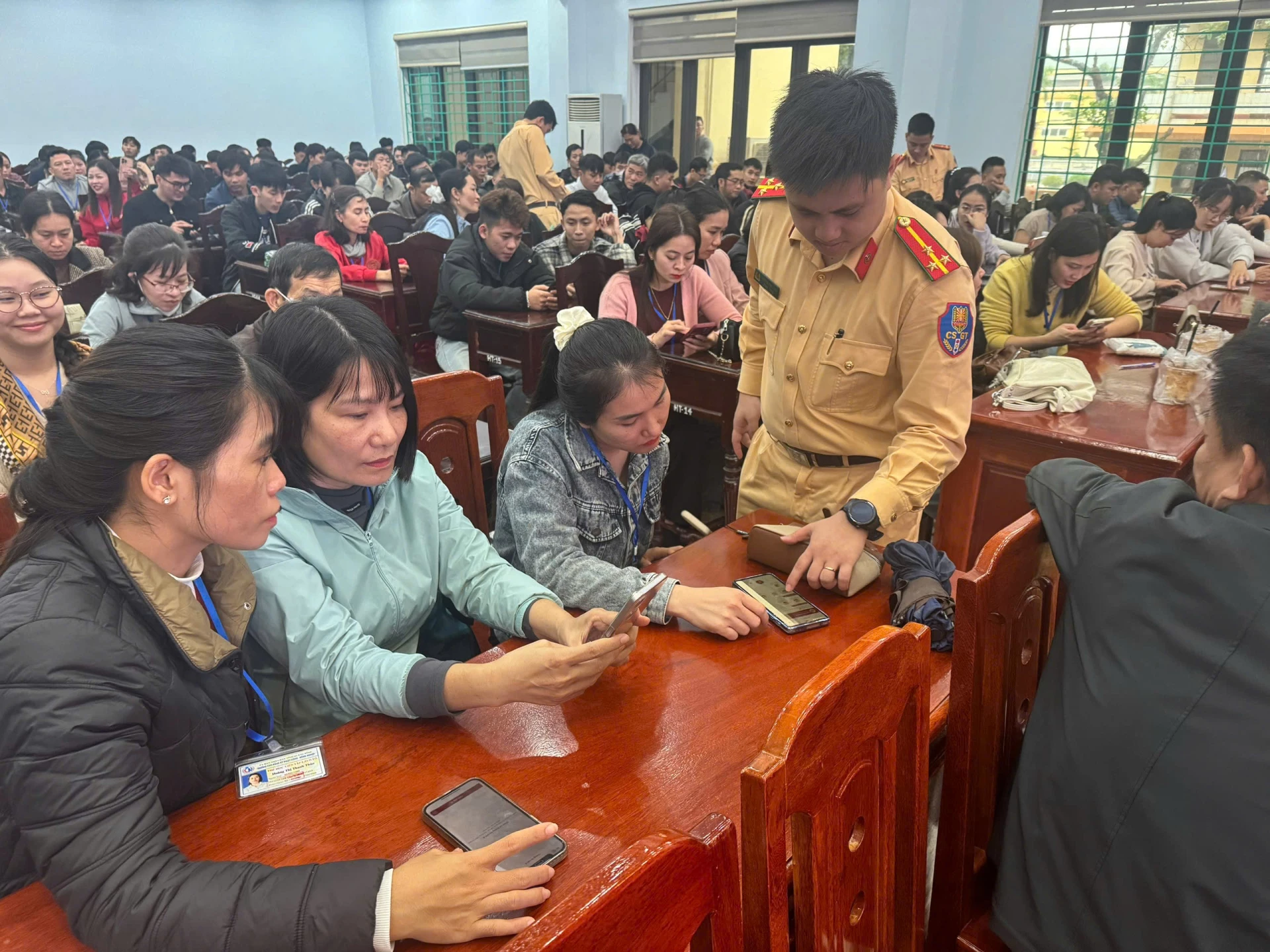 Cán bộ Phòng Cảnh sát giao thông hướng dẫn cách cài đặt và sử dụng các tiện ích của ứng dụng VNeTraffic - Ảnh: T.L